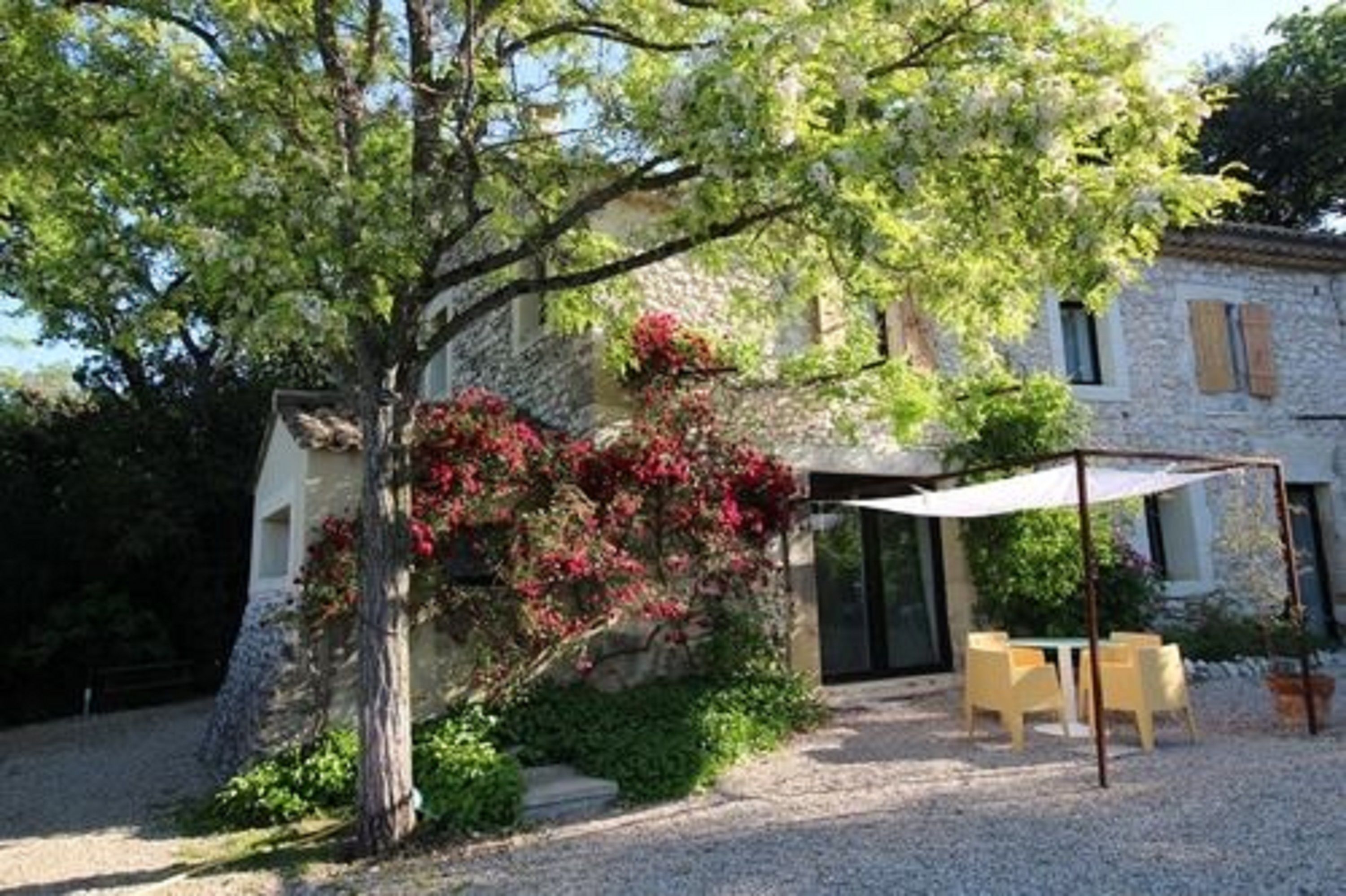 A stone building with a covered patio and outdoor seating.