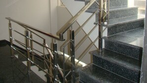 Una escalera moderna con barandales de metal y peldaños de granito.
