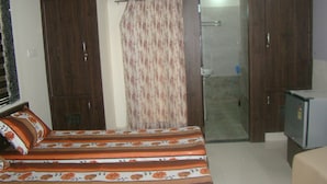 Un dormitorio con cama, armario y televisor.