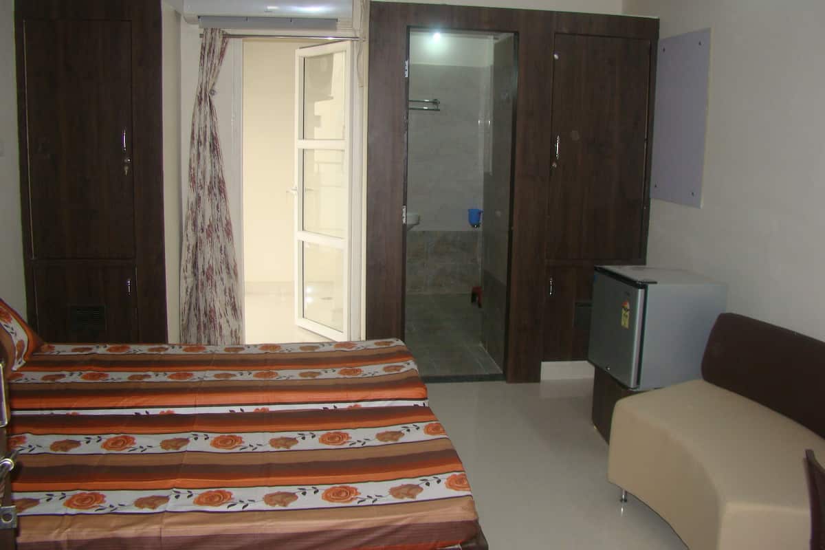 A bedroom with a bed, a TV, and a wardrobe.