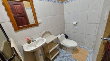 Un baño pequeño con lavamanos, inodoro y espejo.