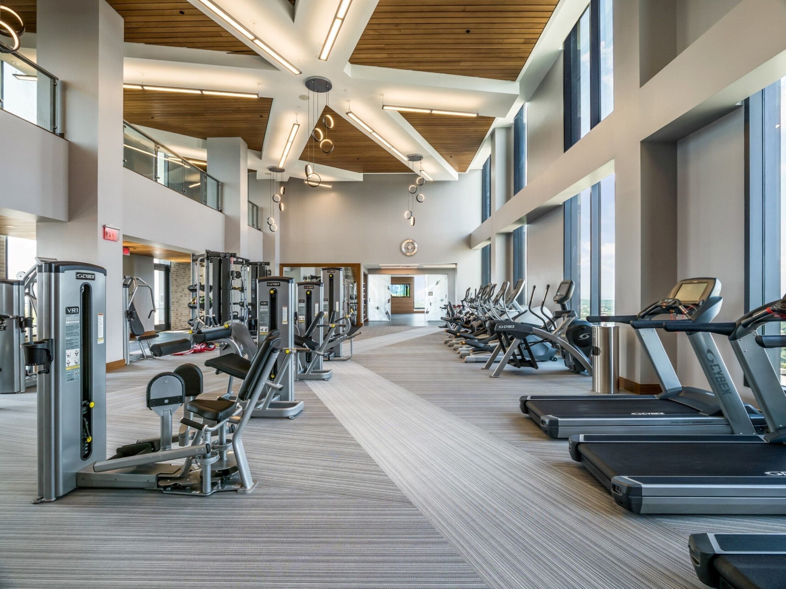 Un gimnasio moderno con máquinas de cardio, zonas de pesas y un diseño espacioso.