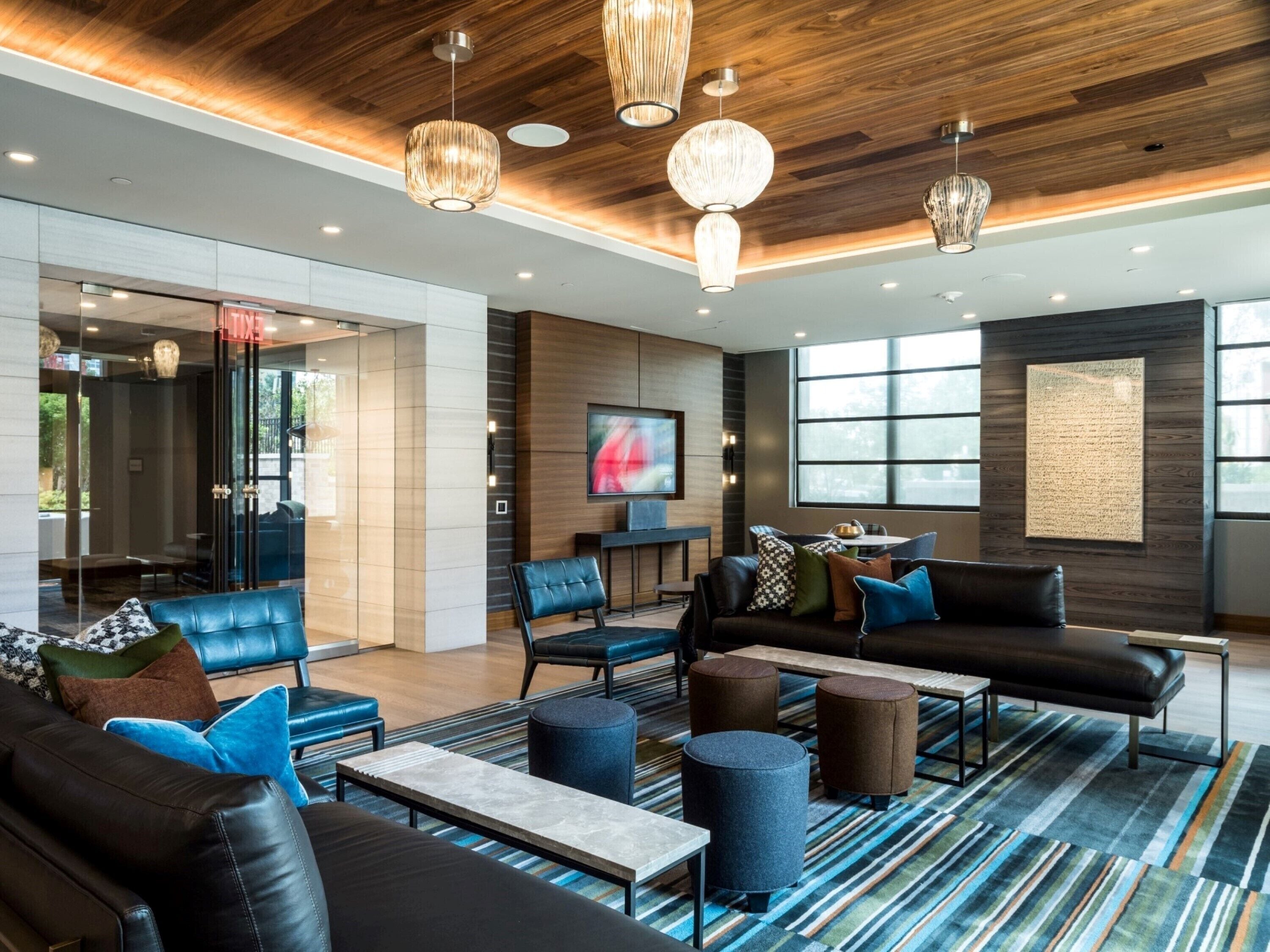 A modern lobby with leather sofas, a coffee table, and a patterned rug.