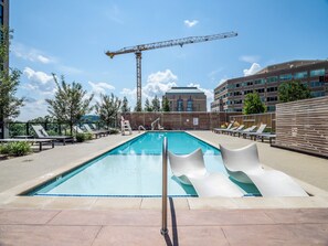A rooftop pool with lounge chairs and a construction crane in the background. - Global Luxury Suites at Reston Town Center (Reston)