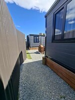 Una hilera de modernas casitas móviles, con camino de grava y terraza de madera.