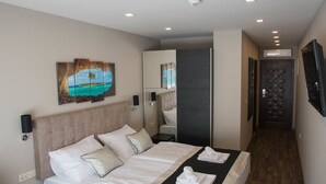 Een moderne hotelkamer met een groot bed, nachtkastjes, een bureau en een telefoon.