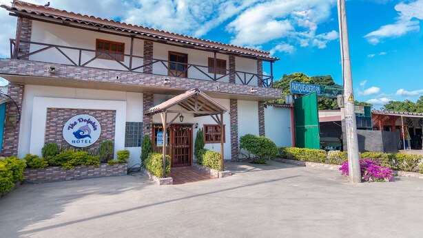 Un hotel con tejado de baldosas, un balcón y un letrero que indica que es un hotel.