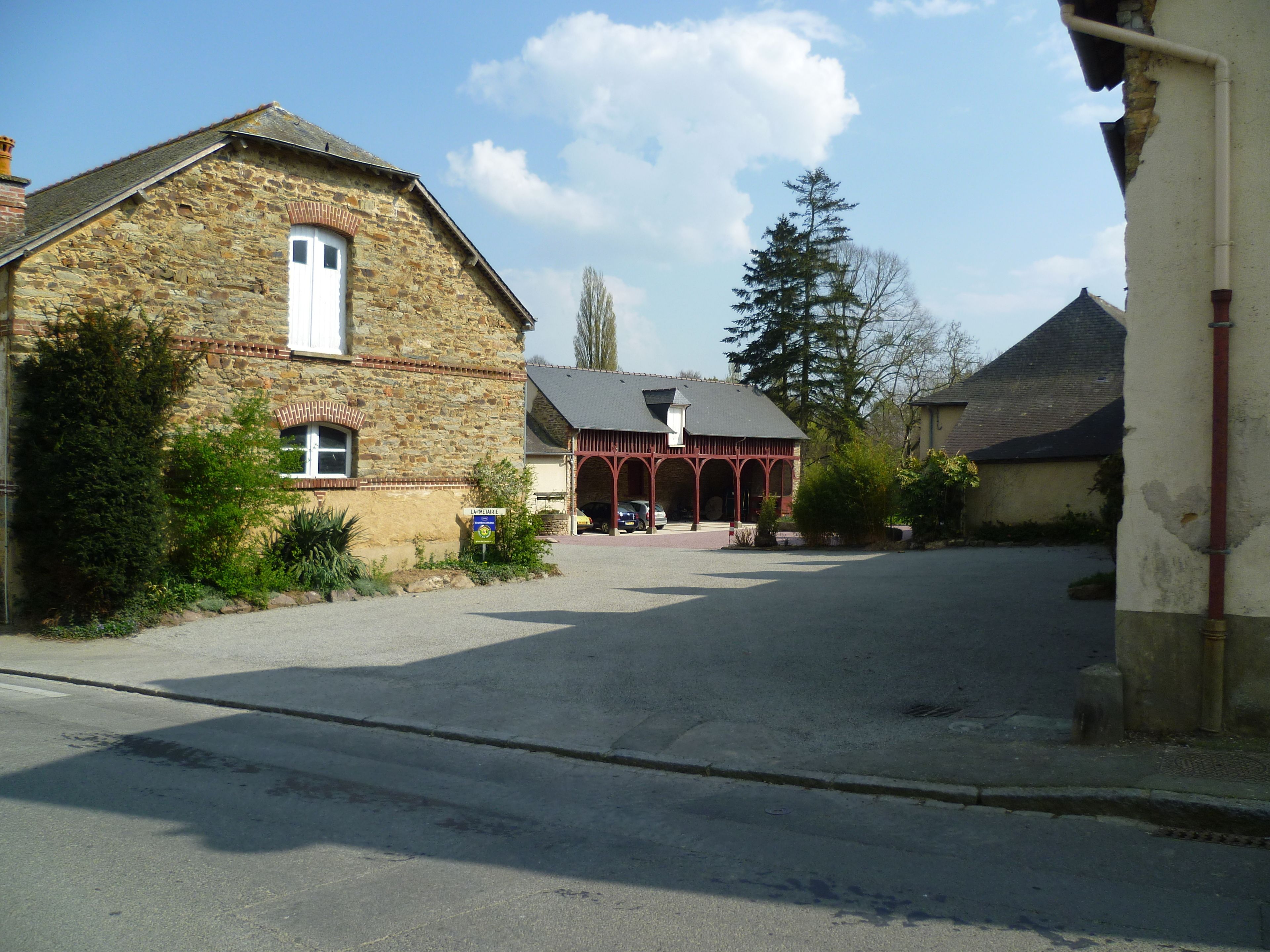 A stone building with a red porch and a sign indicating a restaurant.