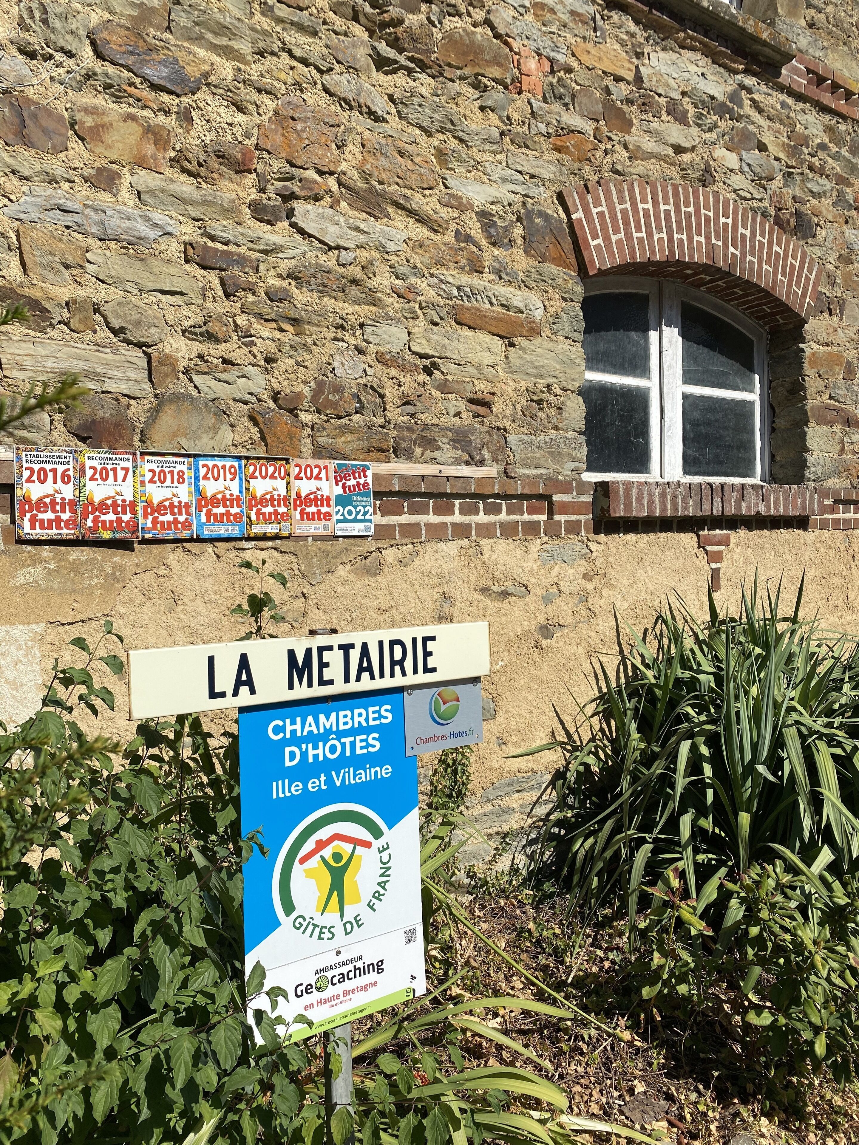 A stone building with a window and multiple signs indicating years from 2016 to 2022.