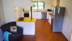 A compact kitchen with a dining area, a refrigerator, and a dishwasher. - Egrets Rest - Daintree (Daintree)