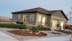 Une maison d’habitation avec un jardin devant, une allée et un petit espace jardin.