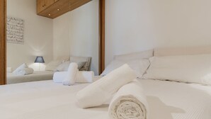 A hotel room with a large bed, a smaller bed, and a nightstand with a lamp. - Lago Terrione Apartment - Charme Holidays (Rome)