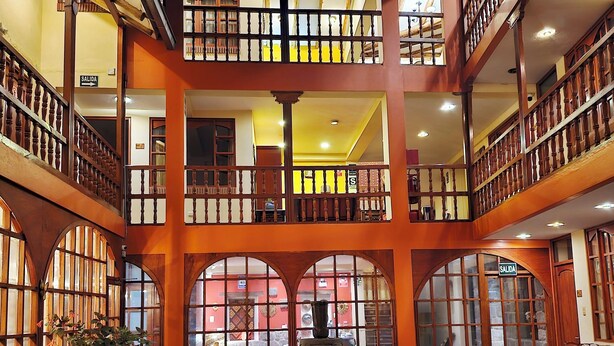 A multi-level atrium with a central fountain, potted plants, and a staircase. - Amerindia Hotel (Cusco)