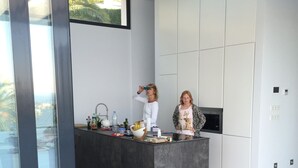 A modern kitchen with a central island, white cabinetry, and a large window. - luxurious, state-of-the-art villa with beautiful views (Denia)