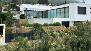 A modern house with a glass facade, stone steps, and a view of a mountainous landscape. - luxurious, state-of-the-art villa with beautiful views (Denia)