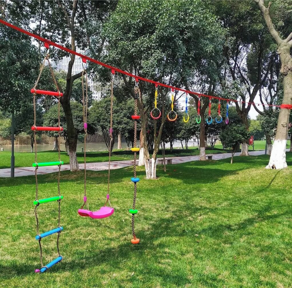 A park with swings and a red rope swing set.