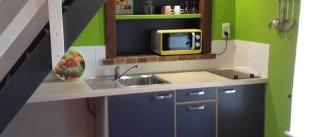 A kitchen with a microwave, sink, and cabinets.