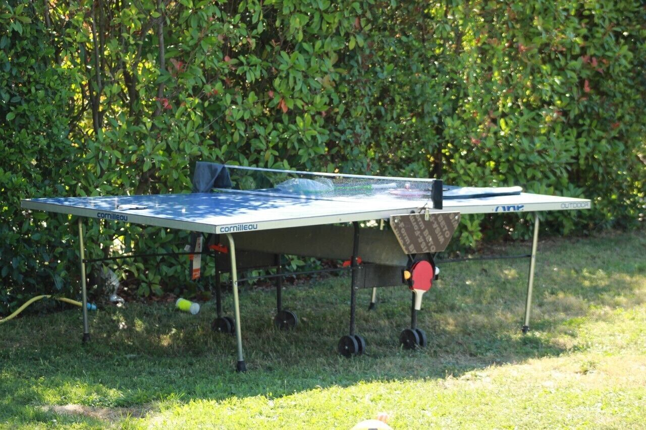 A portable table tennis table set up outdoors with a net and paddles.