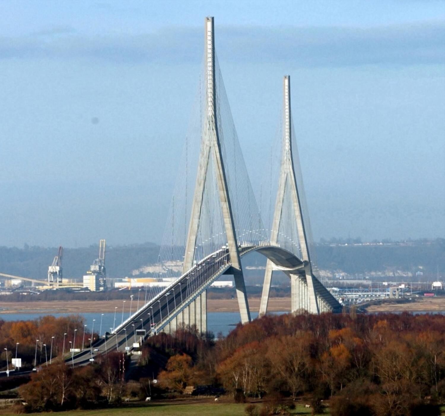 Un puente colgante grande con dos torres altas y una calzada que cruza un cuerpo de agua.