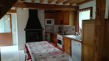 Une cuisine avec des meubles de rangement en bois, une cuisinière, un four à micro-ondes et un lave-vaisselle.