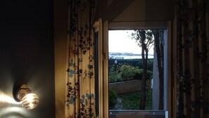 A room with a window overlooking a bridge and greenery. - Very beautiful T2 on the ground floor with trees, swimming pool, sea view, shops and beach  (Six-Fours-les-Plages)