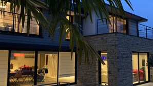 Een modern gebouw met twee verdiepingen, een stenen gevel, grote ramen en een balkon.
