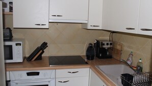 A kitchen with white cabinets, a microwave, a toaster, and a coffee maker.