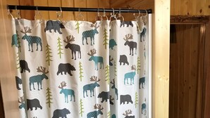 Cortina de ducha con un estampado de alces y árboles.