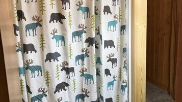 A shower curtain with a pattern of moose and trees.