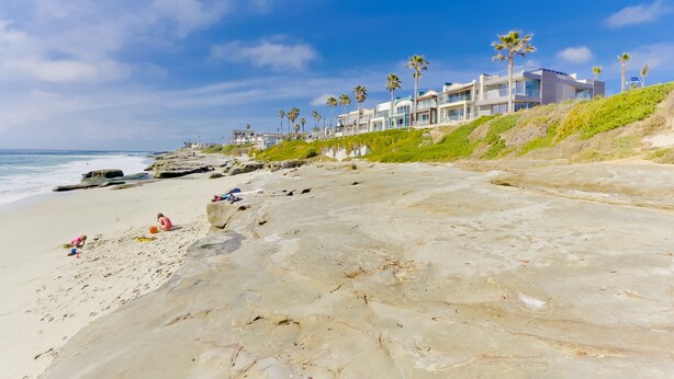 A beach with a row of modern houses, palm trees, and a clear blue sky. - Sandcastle Hideaway, Dog Friendly, Designer Studio, Private Patio And Parking! (La Jolla)