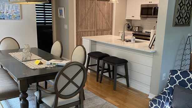 A modern kitchen with a central island, wooden cabinets, and a microwave. - Palmetto Dunes-Golf-Pickleball-Tennis- Beach! (Hilton Head Island)