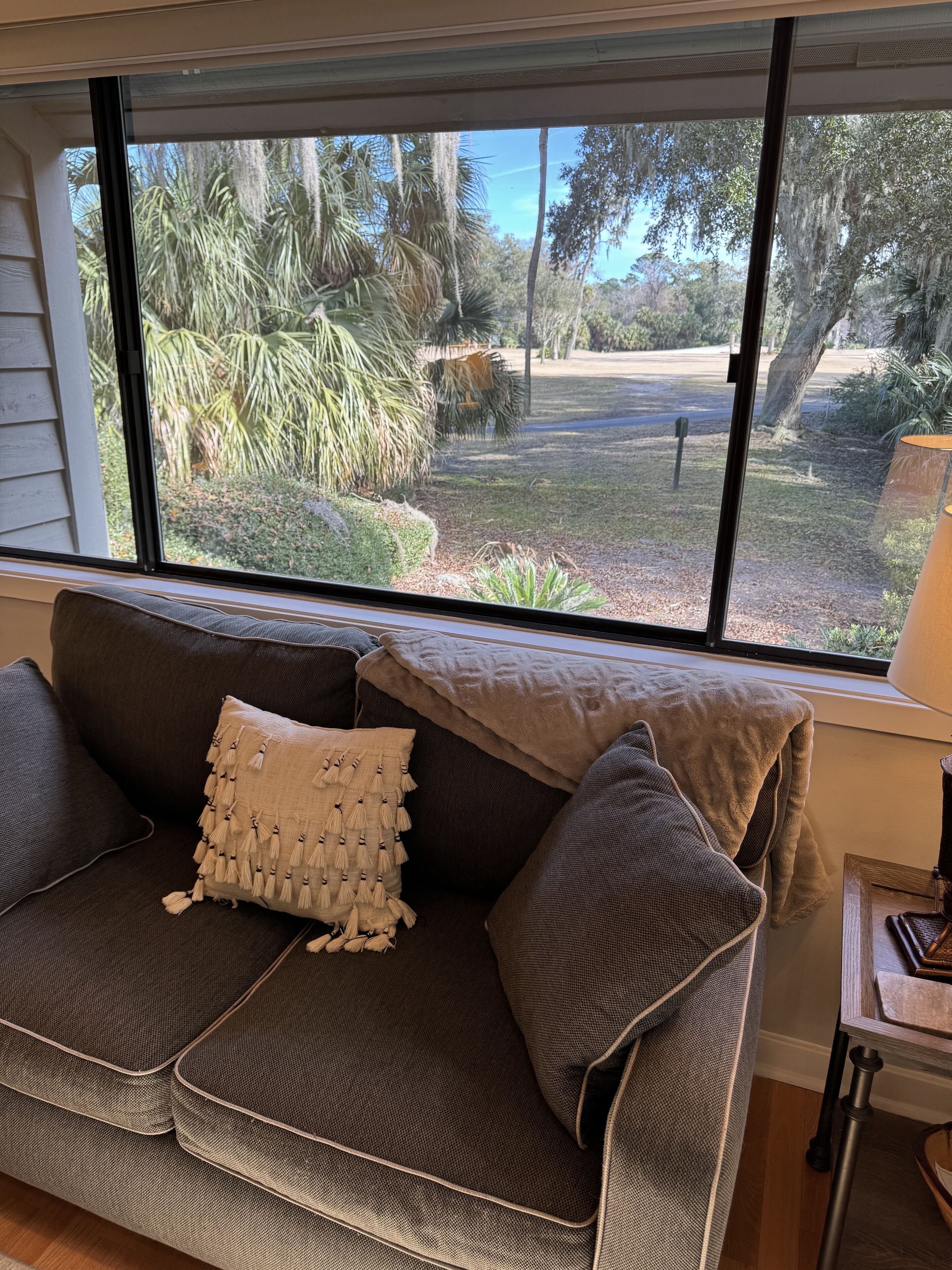 A modern living room with a large window offering a view of a landscaped garden.