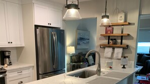 A modern kitchen with white cabinetry, stainless steel appliances, and a marble countertop. - Palmetto Dunes-Golf-Pickleball-Tennis- Beach! (Hilton Head Island)