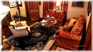 A cozy living room with a sofa, armchair, and a coffee table.