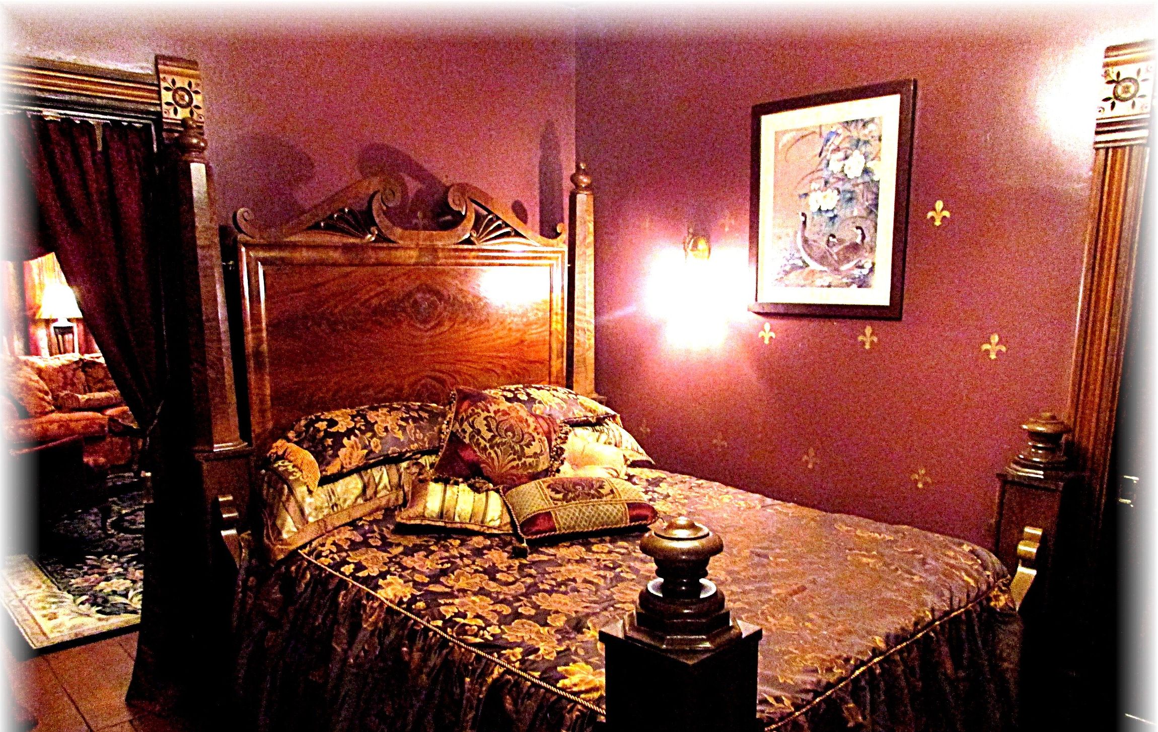 Un dormitorio con una cama grande, un cabecero decorado y una mesita de noche con lámpara.