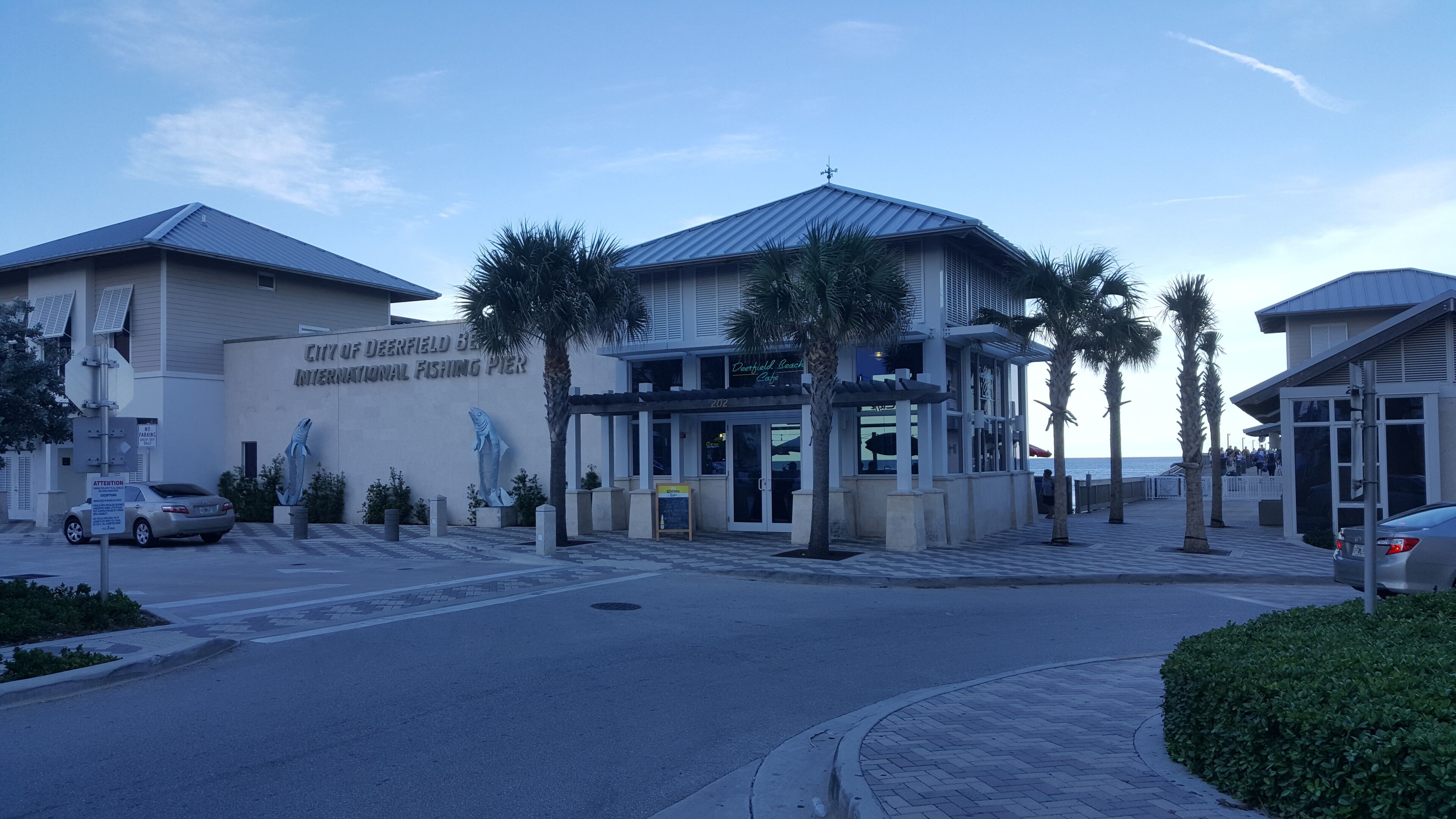 Le ponton de pêche international de Deerfield Beach offre une vue dégagée sur l’entrée, les palmiers et l’aire de stationnement.