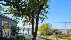 Una proprietà residenziale con vista su un lago, altalene e un prato curato.