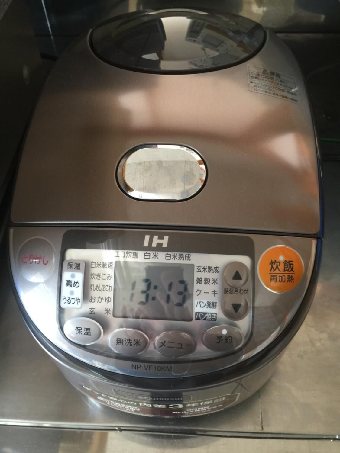 A rice cooker with Japanese labels and a digital display.