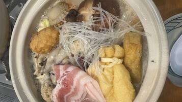A bowl of ramen with various toppings including noodles, meat, and vegetables.