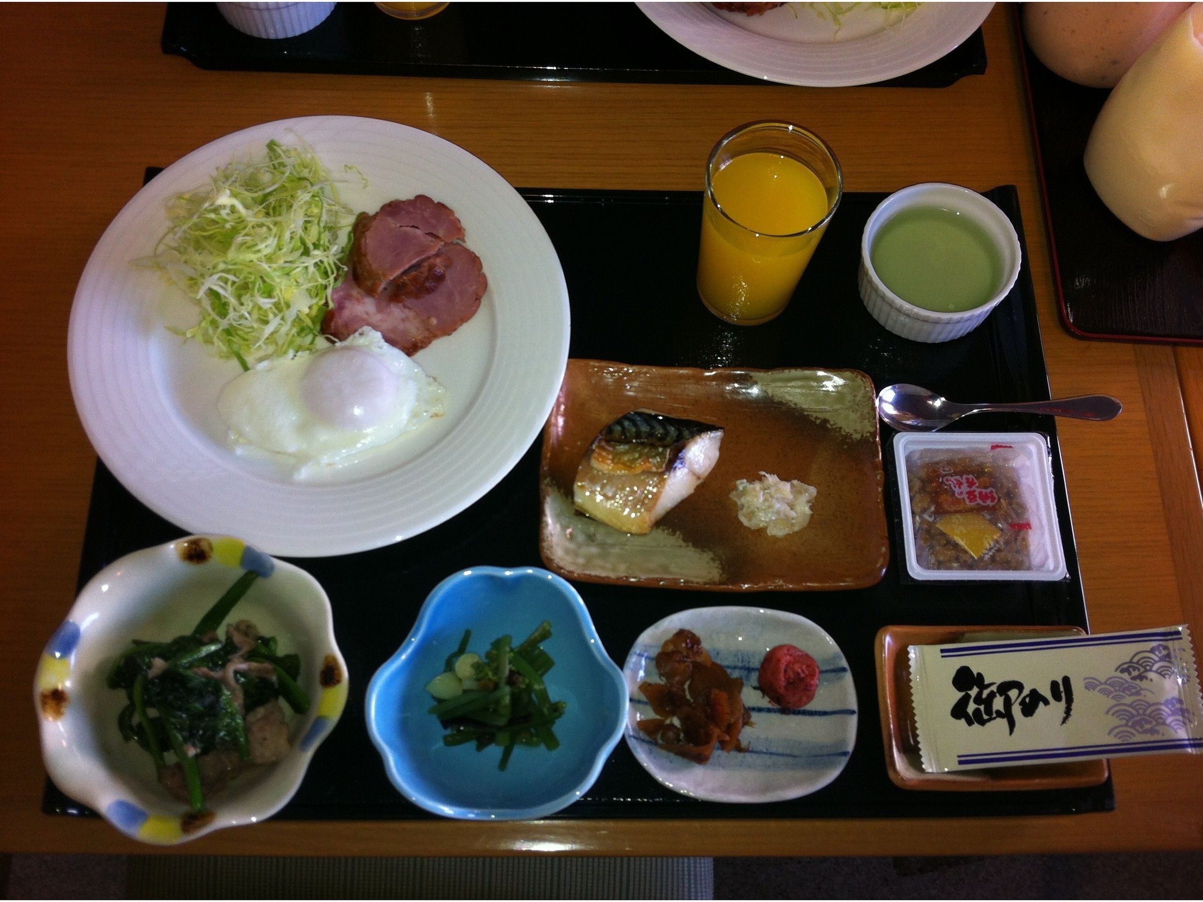 A tray with various breakfast items including eggs, fish, and vegetables.