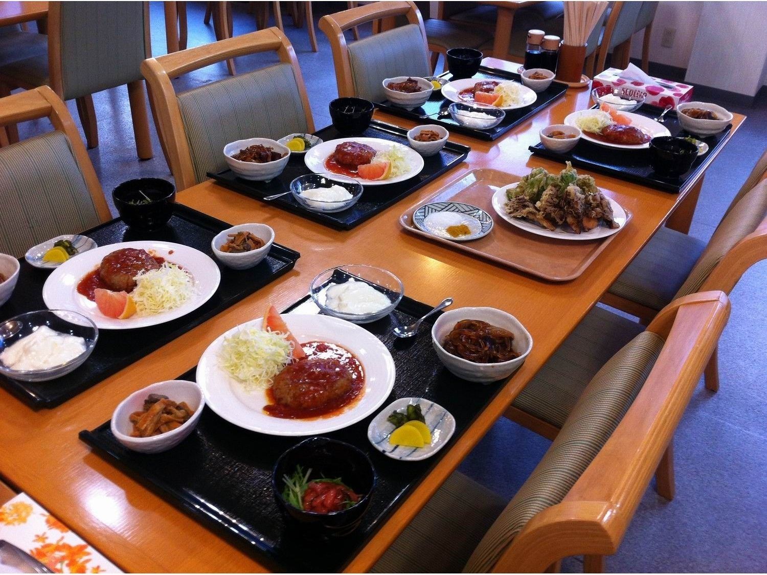A dining table set with various dishes, including plates of food, bowls, and trays.
