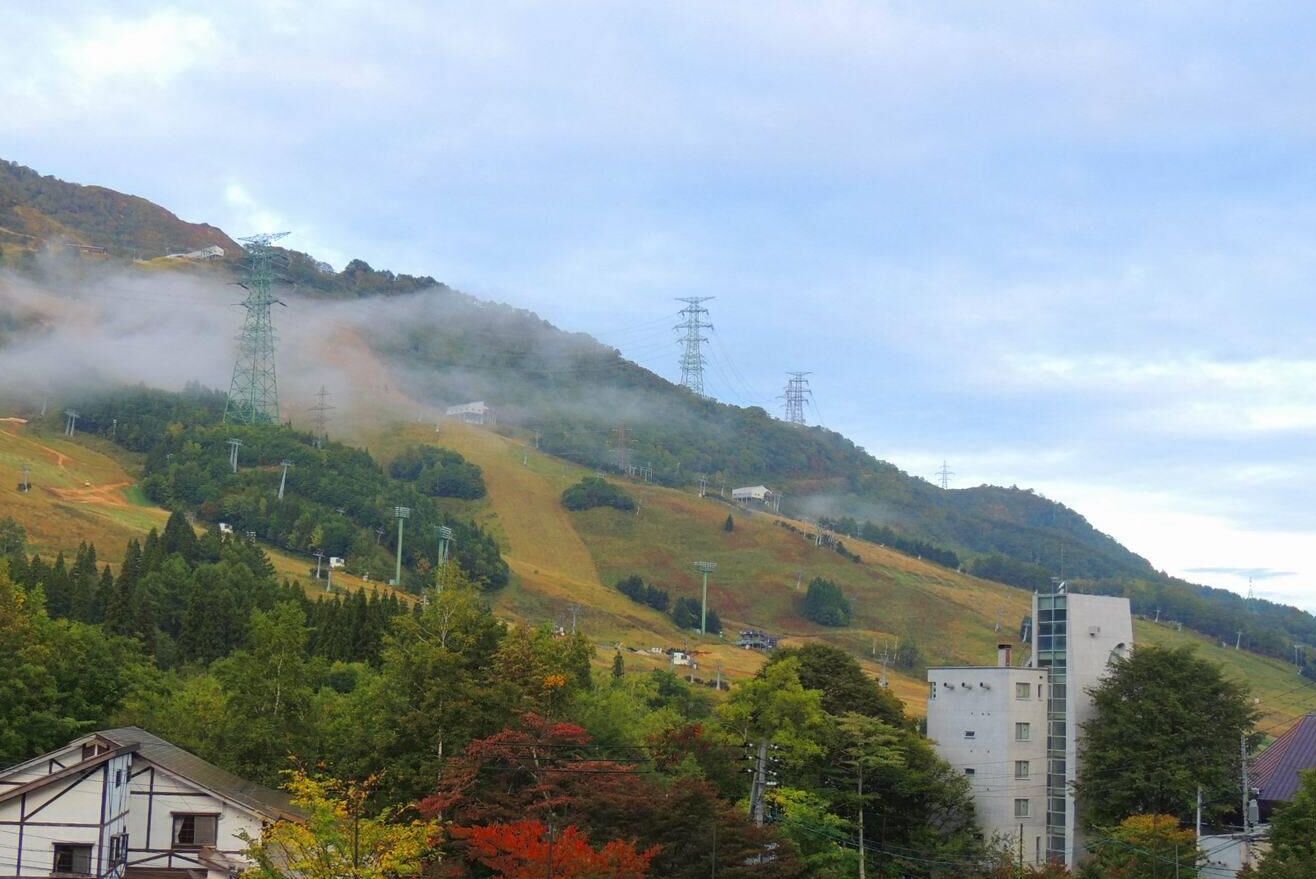 A mountainous landscape with a building and power lines.