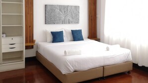 Un dormitorio moderno con una cama grande, un armario y una obra de arte colgada en la pared.