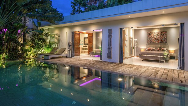 A modern house with a swimming pool, a bedroom with a bed and nightstand, and a living area with a sofa and coffee table. - Villa Sawah (Seminyak)
