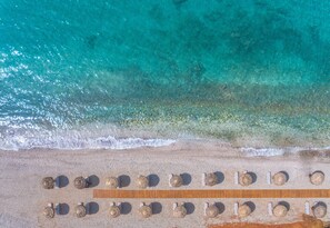 An aerial view of a beach with rows of sun loungers and a wooden deck. - King Maron Beach Hotel & Spa (Maroneia-Sapes)