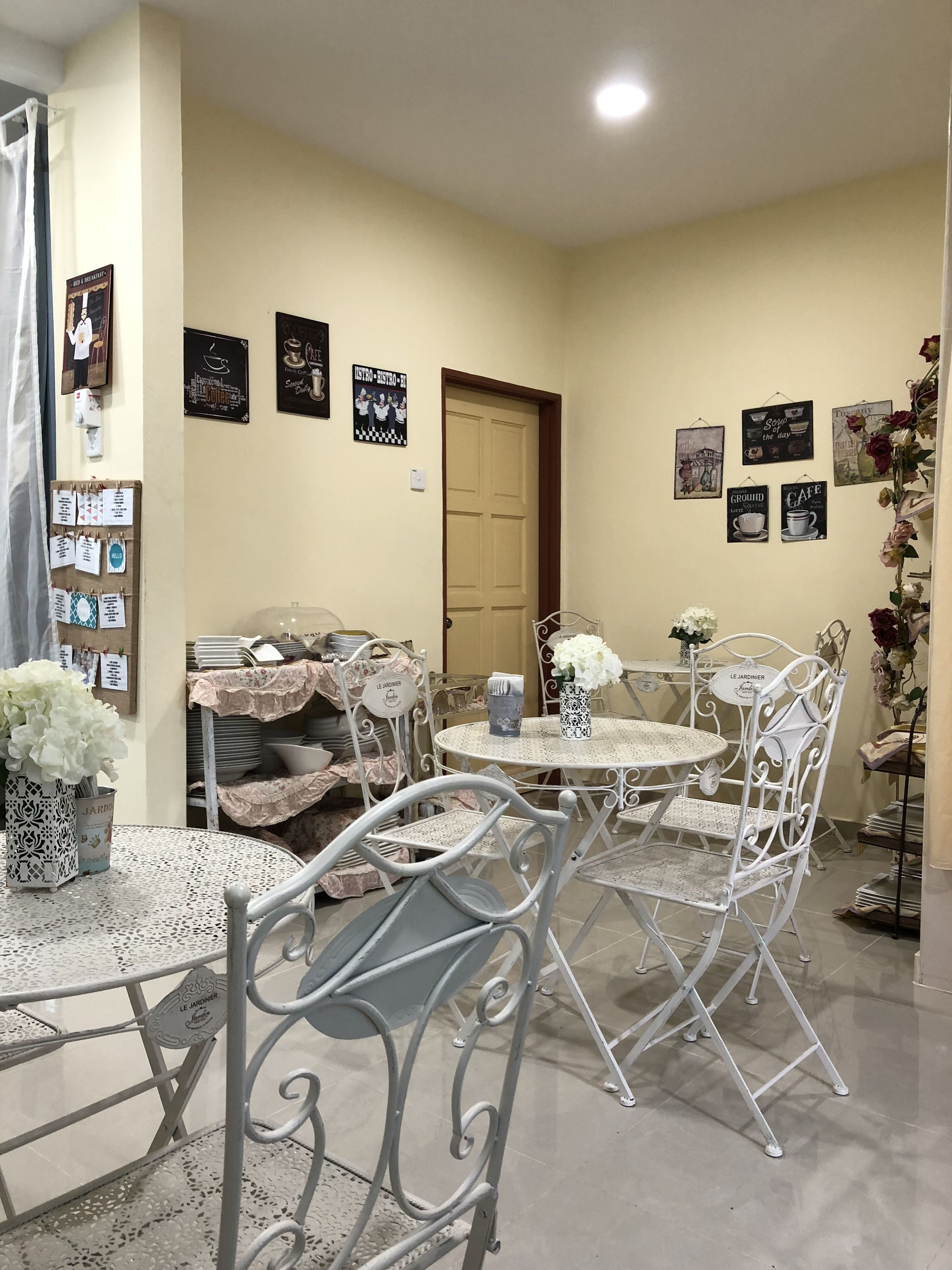 A dining area with metal chairs and tables, a door, and wall decorations.