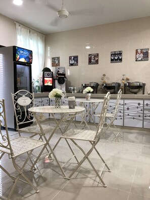 Una cocina moderna con una isla central, sillas blancas y un refrigerador.