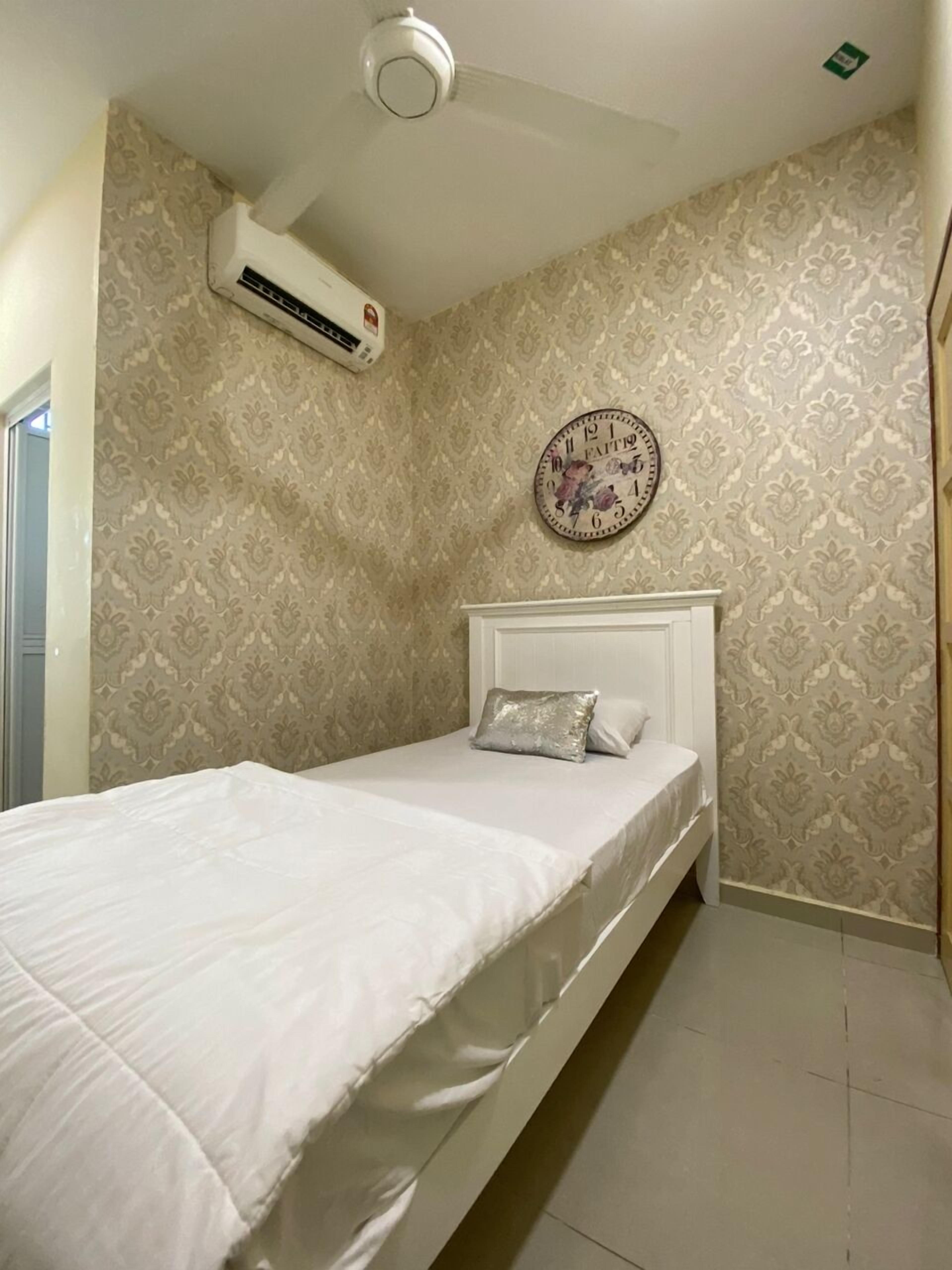 Une chambre à coucher avec un lit, une horloge murale et un appareil de climatisation.