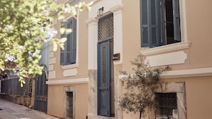 A building with a beige facade, blue shutters, and a small tree in front. - Bohemian Suites Athens - Maison Hotel Adults Only (Athens)