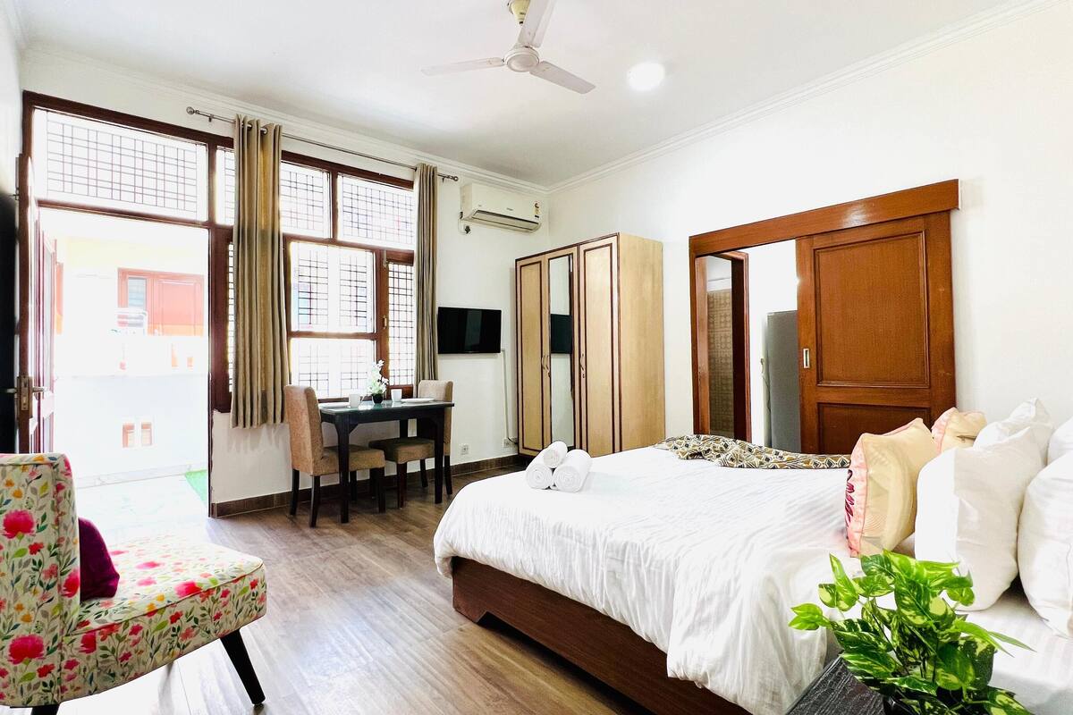 Una habitación de hotel con cama, escritorio, silla y armario.